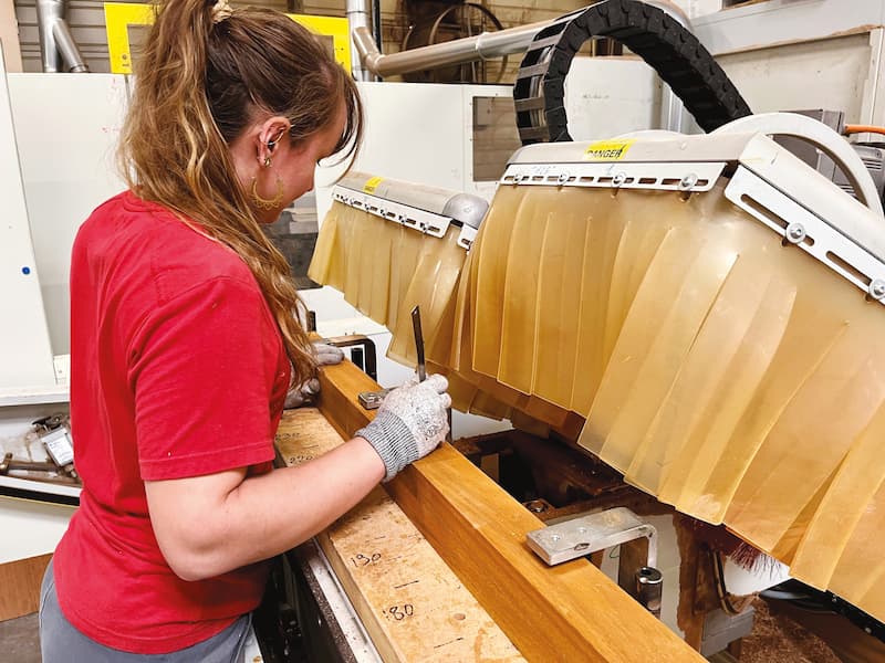 Une menuisière sur la ficheuse à l'atelier